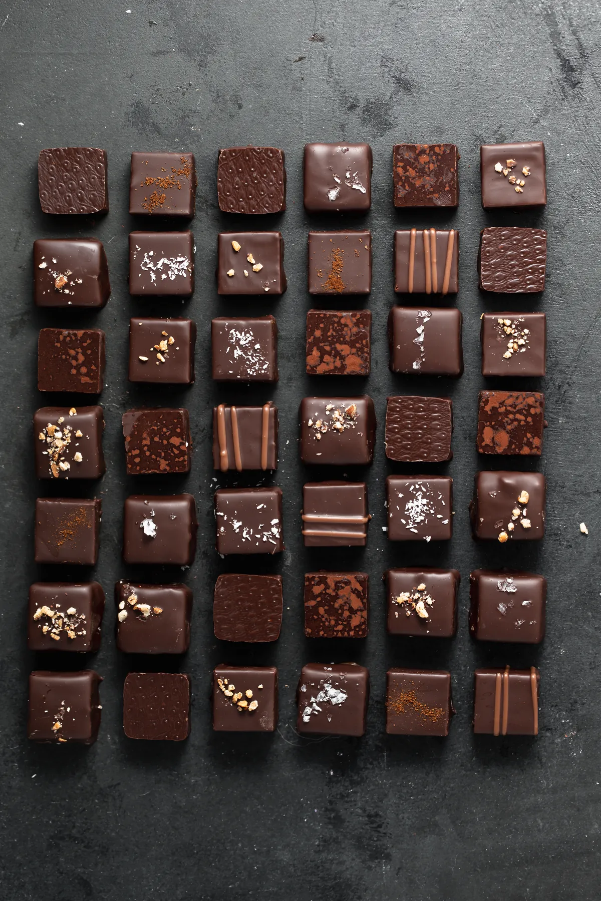 Rows of hand-finished bonbons on slate